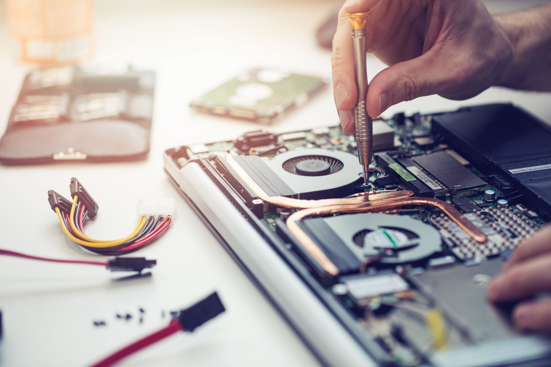 Close-up of a technician's hands performing computer repair services on a laptop. Close-up of a technician's hands performing computer repair services on a laptop.