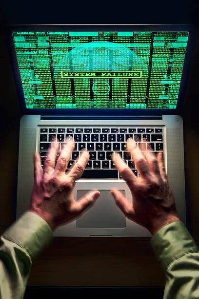 Hands typing furiously on a laptop, screen displaying a