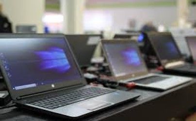 A row of laptops sitting on top of a table.