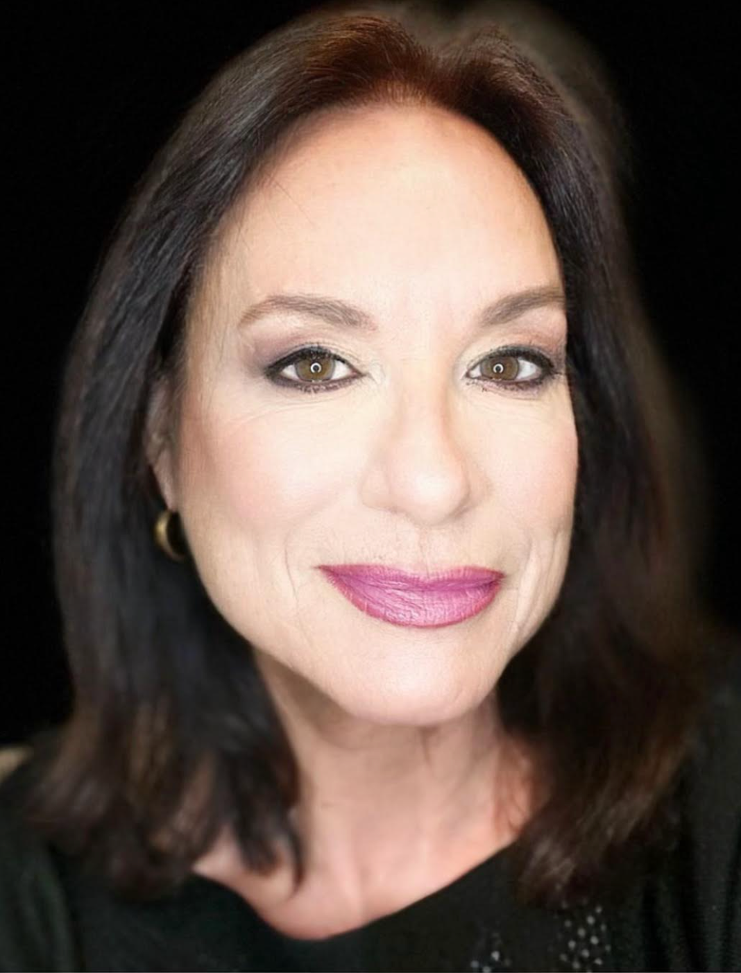 A close up of a woman 's face with a black background.