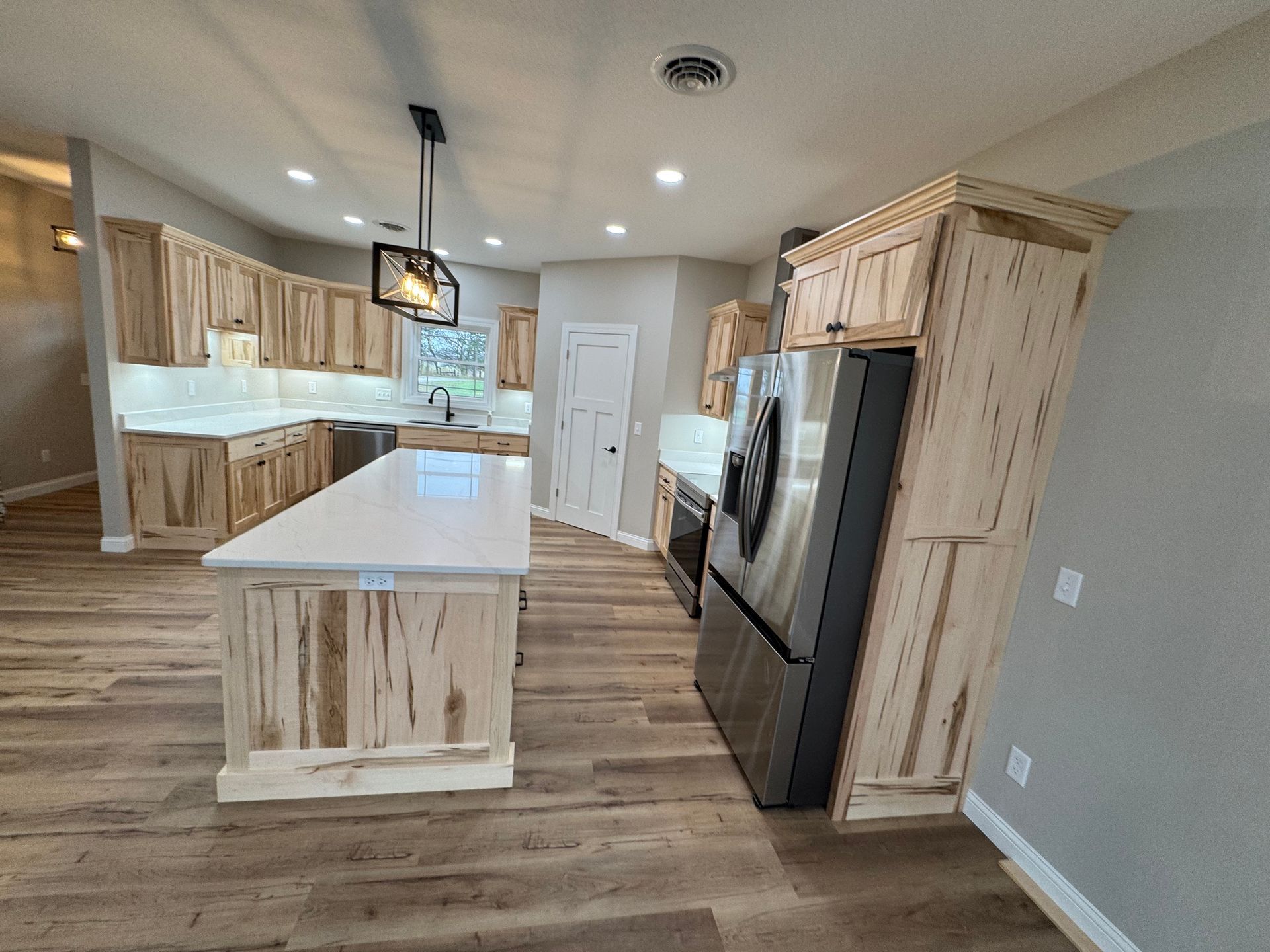 A kitchen with a large island and stainless steel appliances.