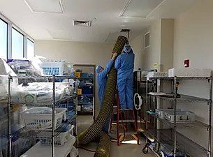 Two employees of Pringle Mega-Vac cleaning an Air Duct