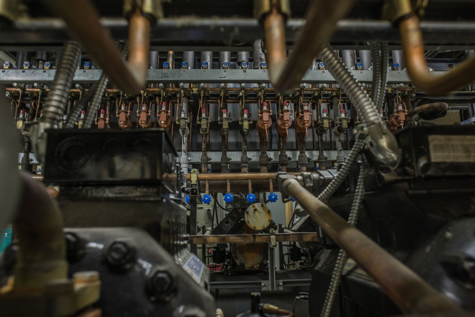 Intricate industrial machinery with copper pipes, metal components, and wires.
