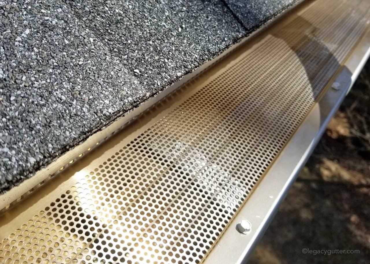 A close up of a gutter on a roof next to a window.