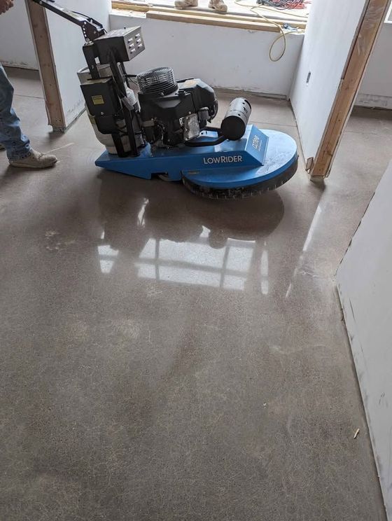 A machine is polishing a concrete floor in a room.
