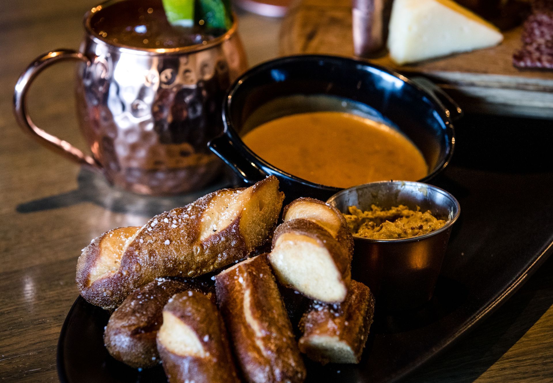 A plate of pretzels and a bowl of soup on a table.