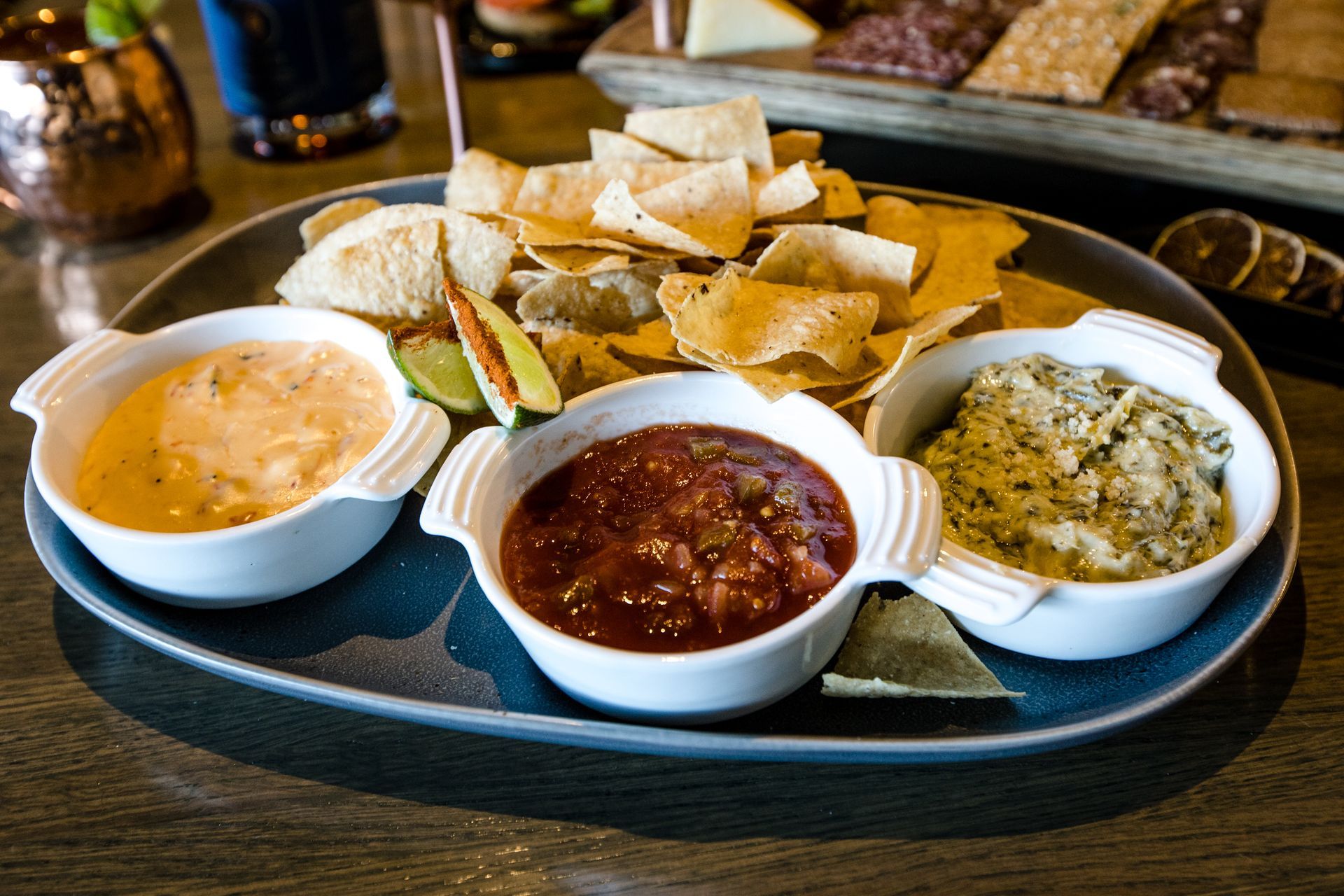 A plate of dips and chips on a table.