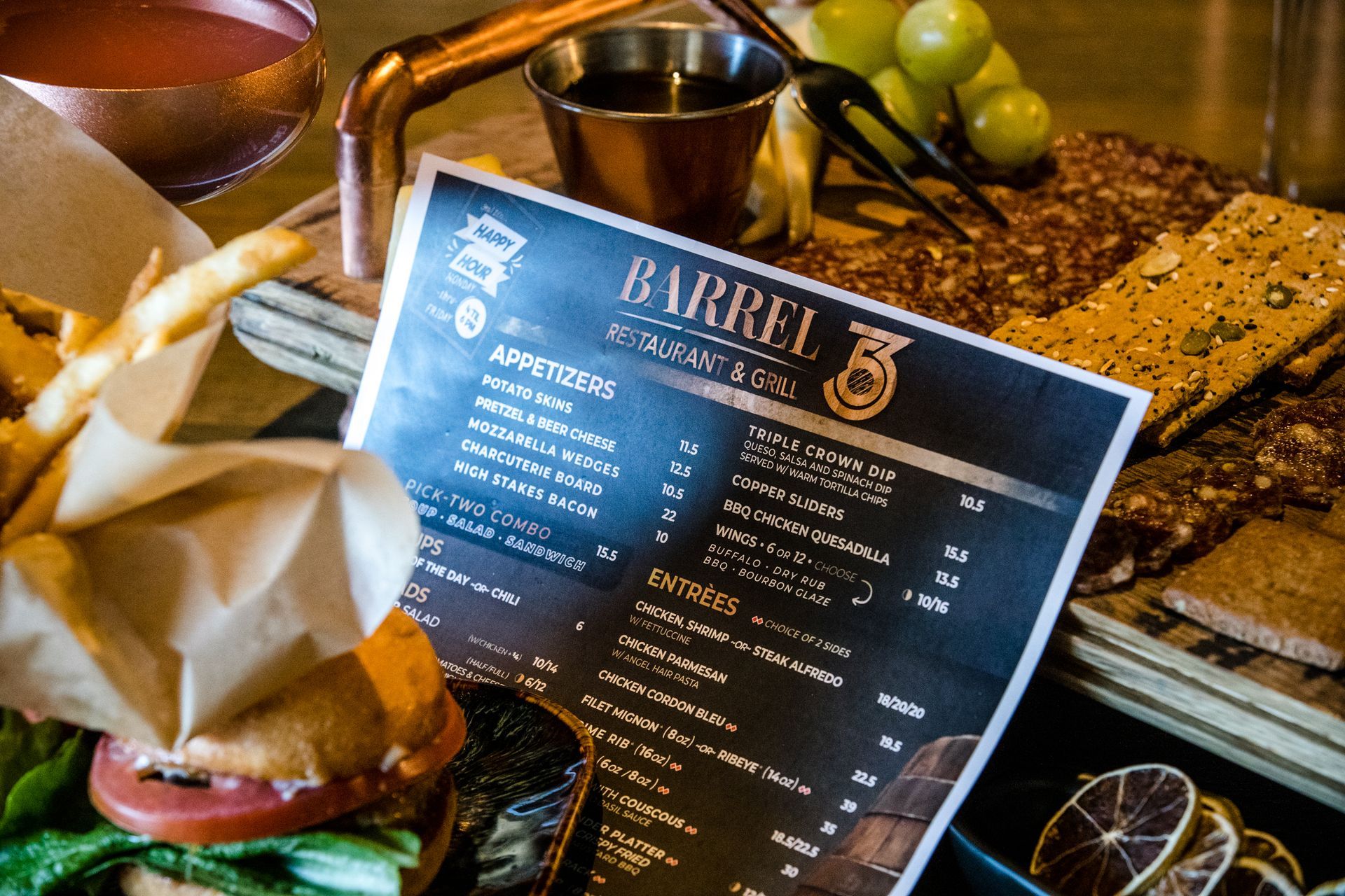 A barrel 3 menu is sitting on a table next to a sandwich and french fries.
