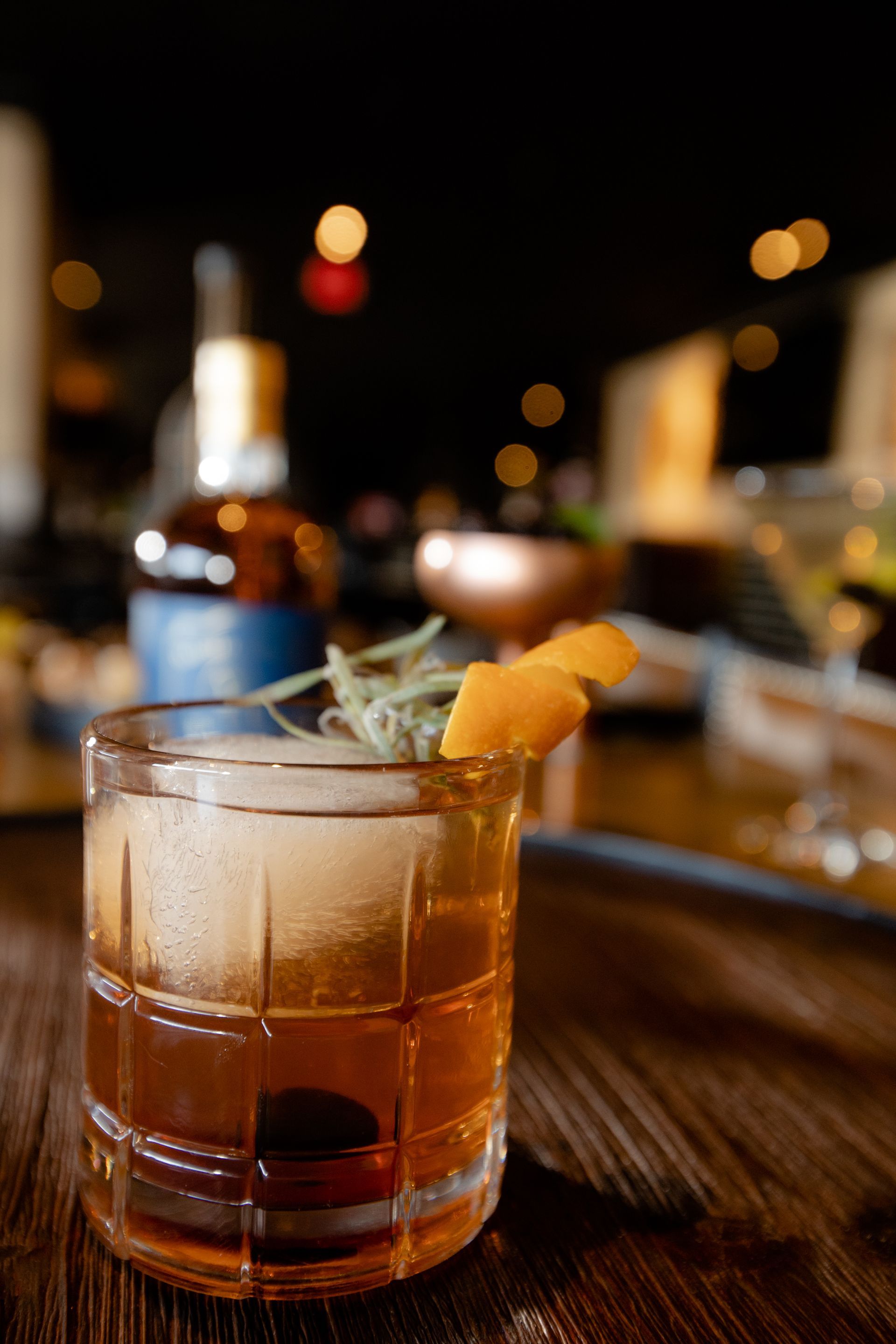 A close up of a glass of whiskey on a wooden table.
