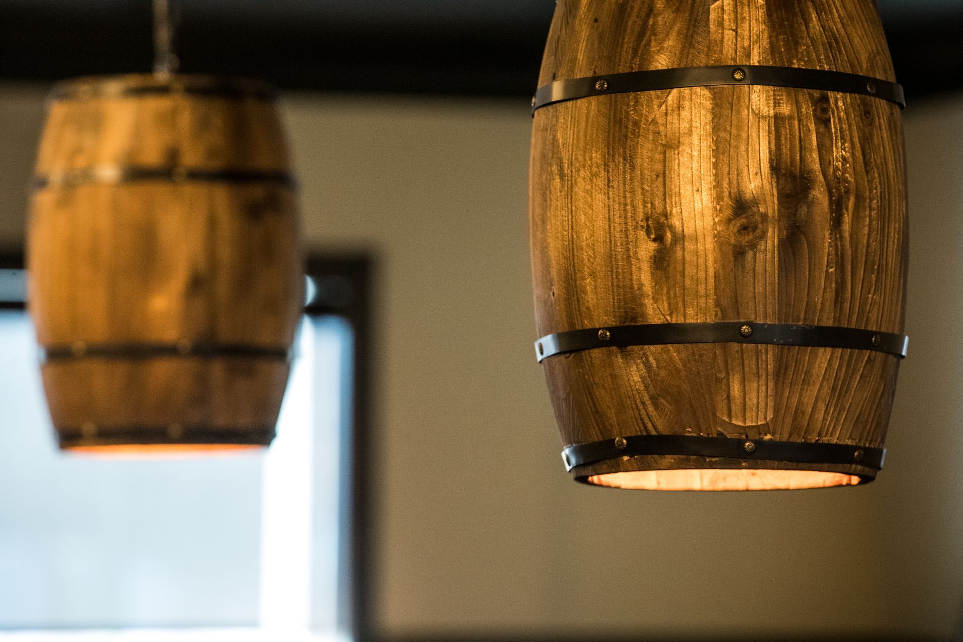 Two wooden barrels are hanging from the ceiling in a room.
