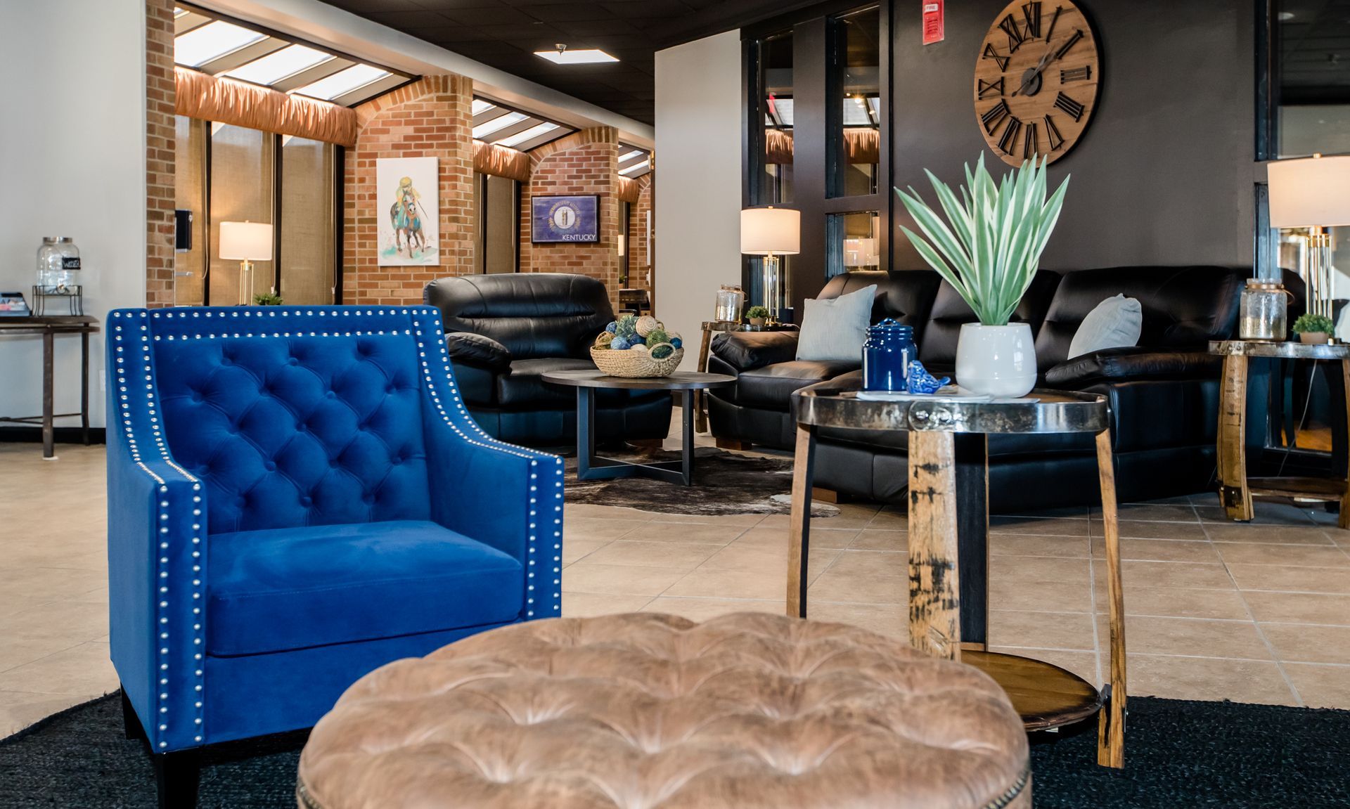 A blue chair is sitting in a living room with a clock on the wall.