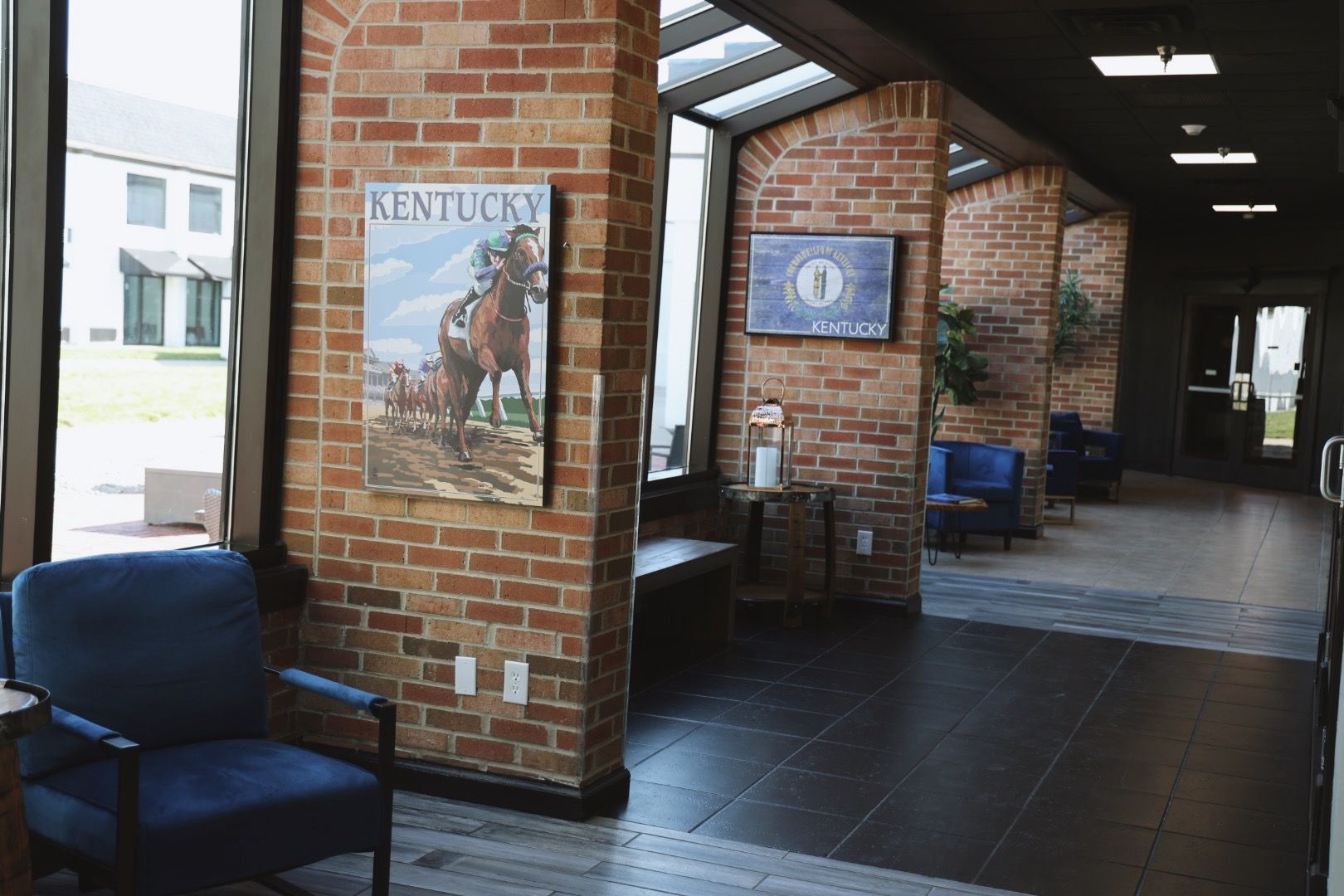 A brick wall with a picture of a horse on it in a hallway.