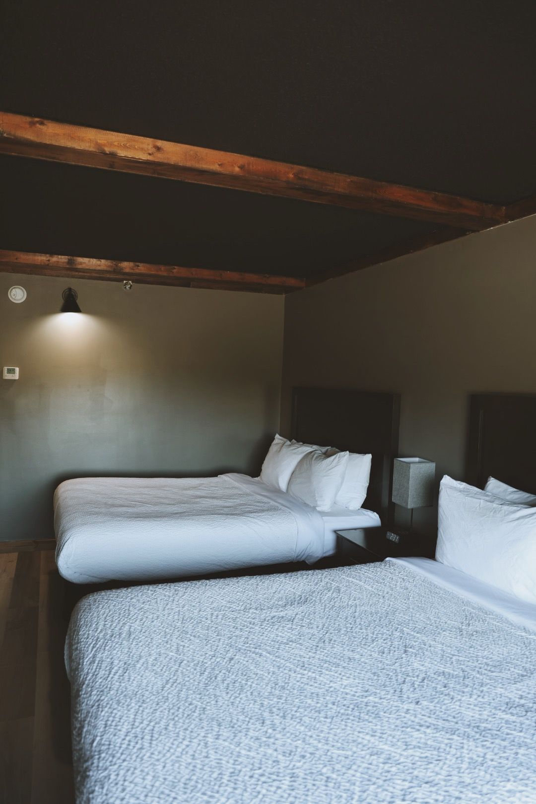 A hotel room with two beds and a black ceiling.