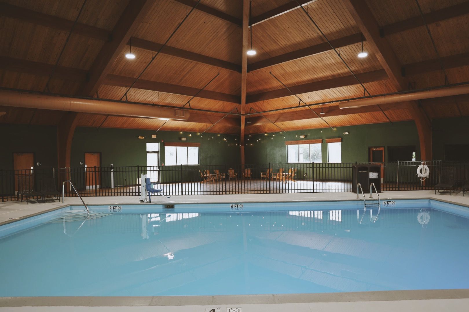 A large indoor swimming pool in a building with a wooden ceiling.