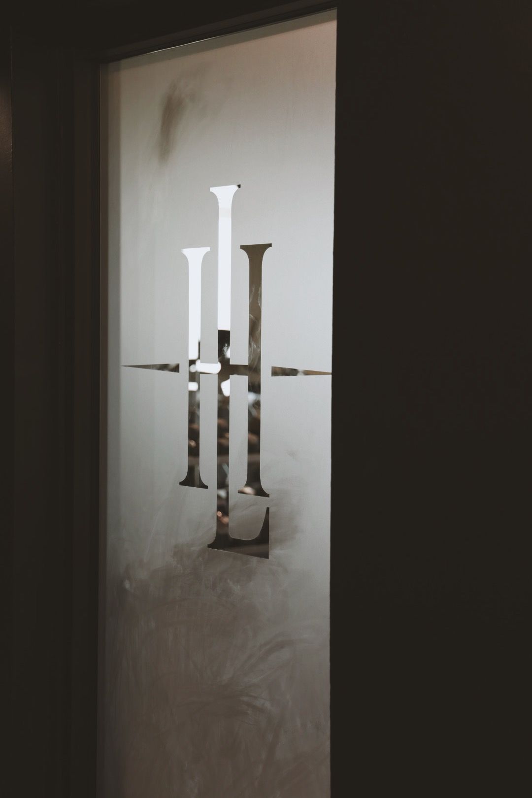 A door with a logo on it that looks like a candle holder.