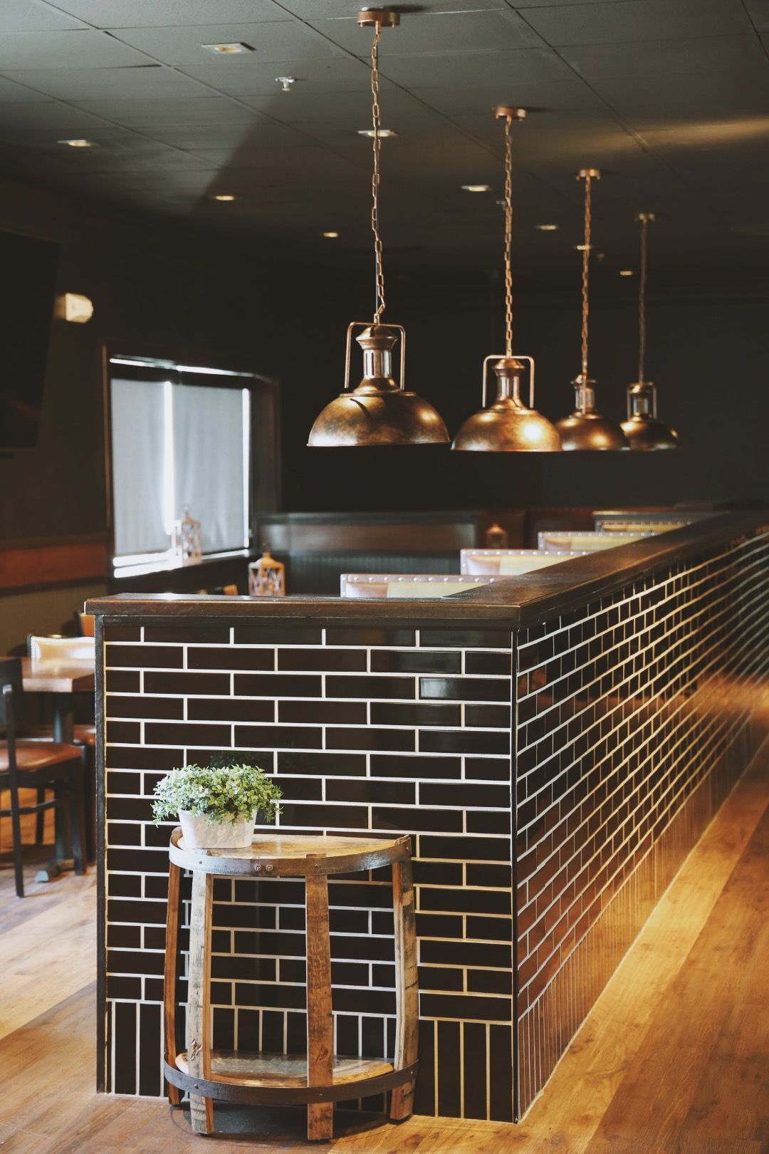 A restaurant with a brick wall and a table with a plant on it.