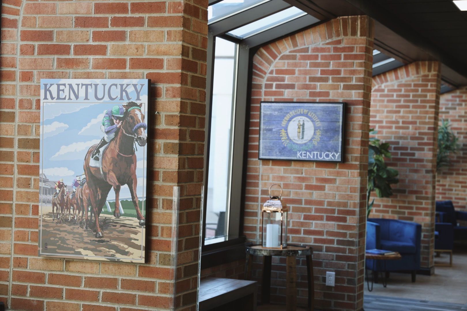A brick wall with a painting of a horse and a sign that says kentucky