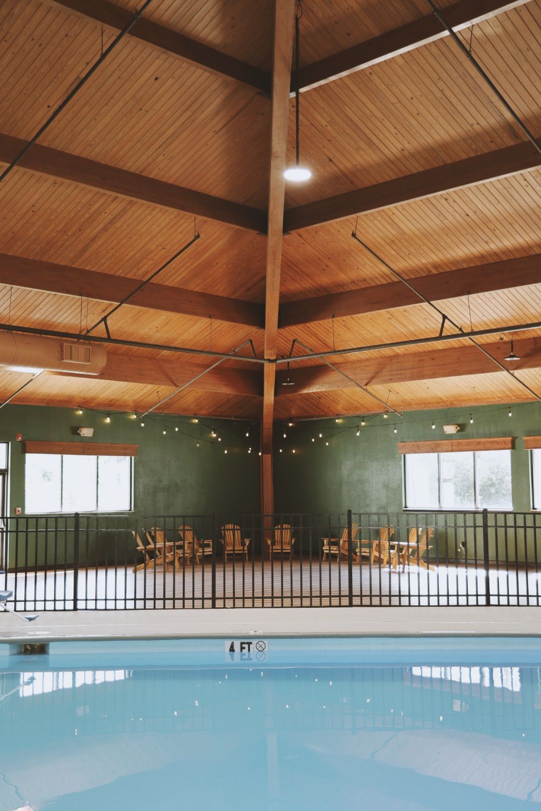 A large indoor swimming pool with a fence around it