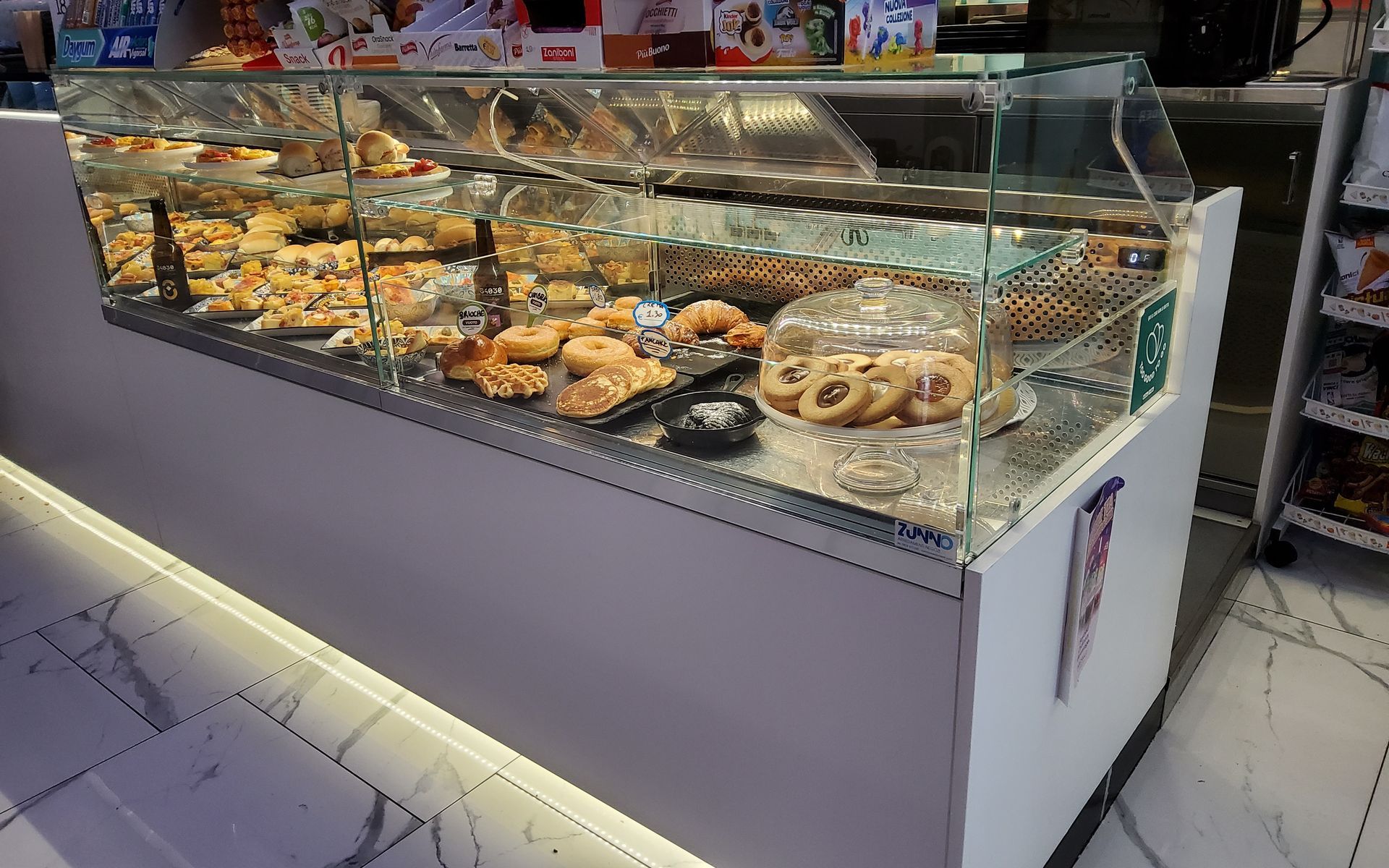 Vetrina di panetteria piena di pasticcini e prodotti da forno.