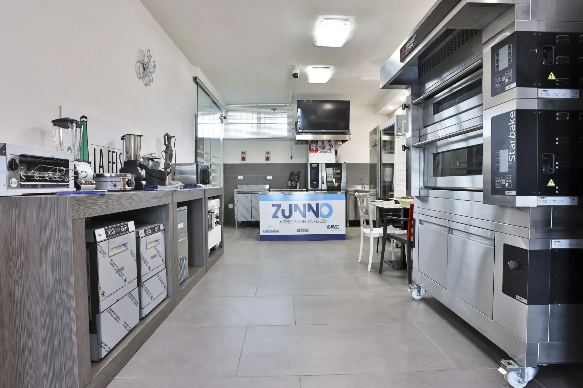 Showroom di attrezzature per cucine commerciali con forni, mixer e altri elettrodomestici.