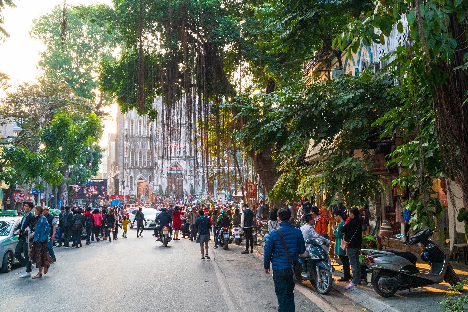 A bustling street scene in front of St. Joseph's Cathedral in Hanoi, Vietnam