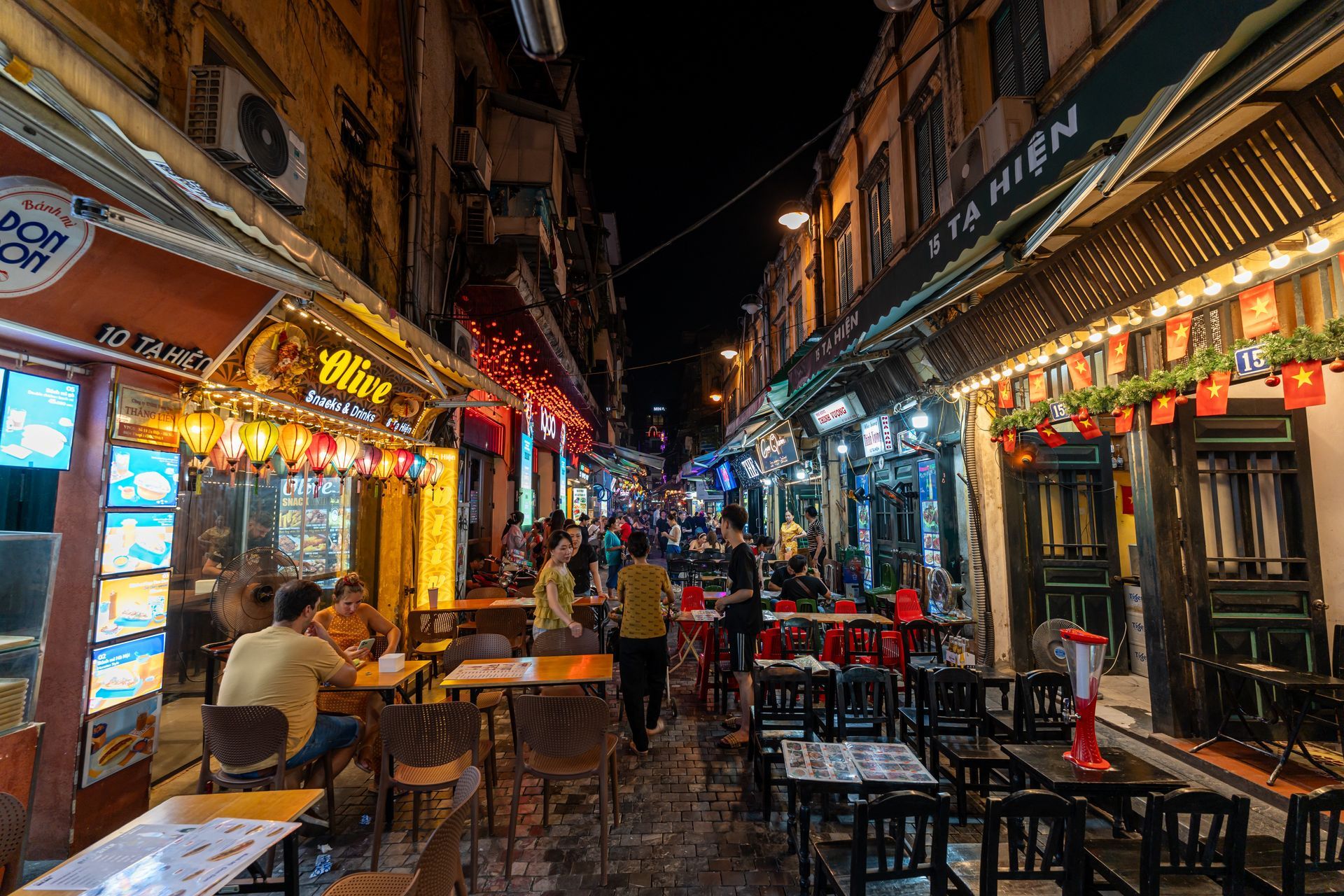 Ta Hien - a lively nightlife hub where locals and international travelers gather on low plastic stools to enjoy cheap fresh draft beer (biạ hơi) and street food.