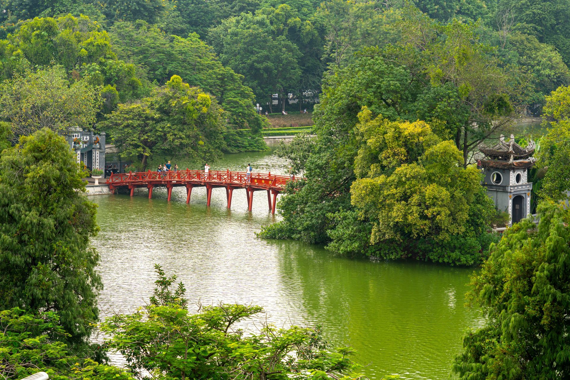 The striking red The Huc Bridge crossing Hoan Kiem Lake and leading to the historic Ngoc Son Temple in Hanoi.