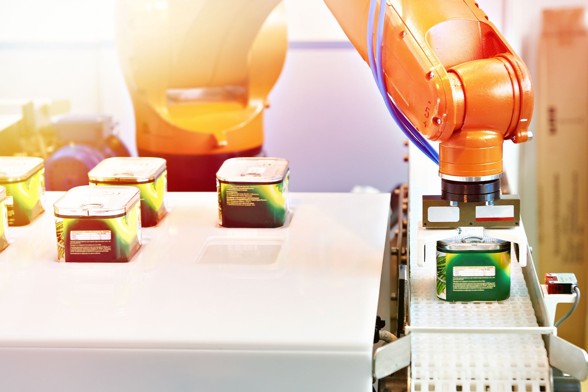 Bottling machine in a factory setting, filling glass bottles with liquid.