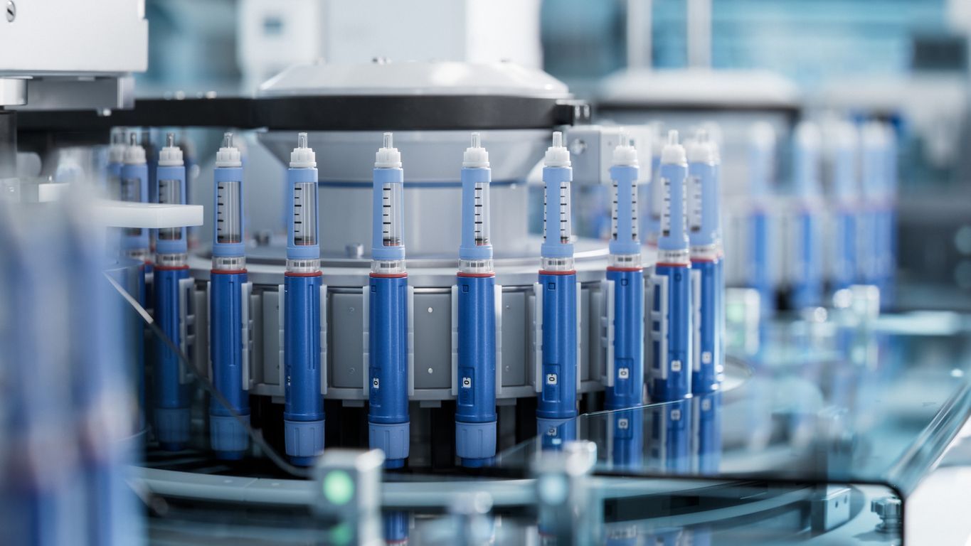 Blue vials on a rotating lab conveyor in a sterile pharmaceutical facility