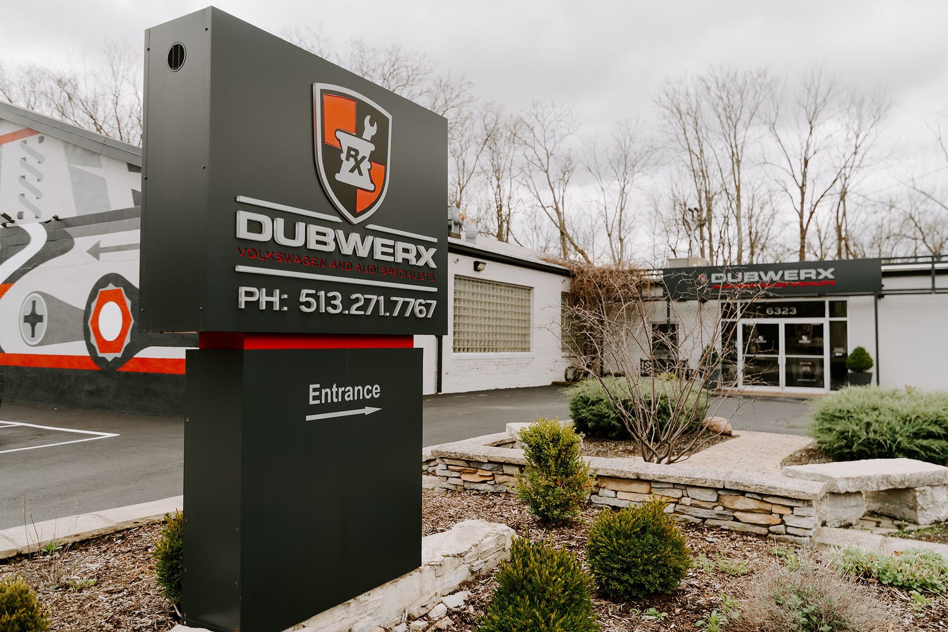 DUBWERX signage outside a modern building with landscaping and leafless trees.