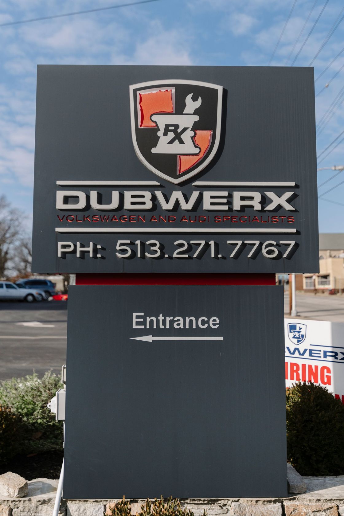 Dubwerx business sign with phone number and “Entrance” arrow on a dark panel outdoors
