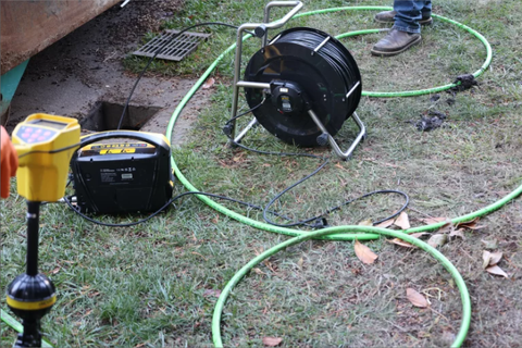 Sewer inspection camera reel, monitor and locating equipment beside a drain