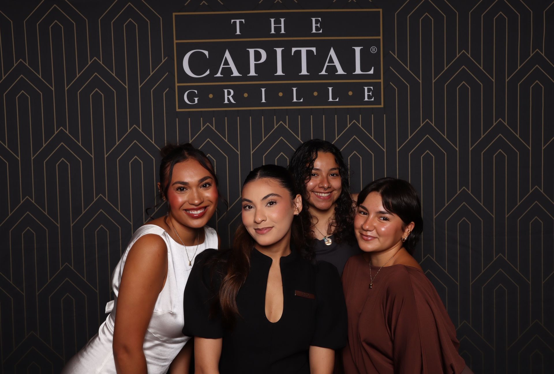 The Capital Grille restaurant staff posing for a printed photo booth picture during the anniversary event
