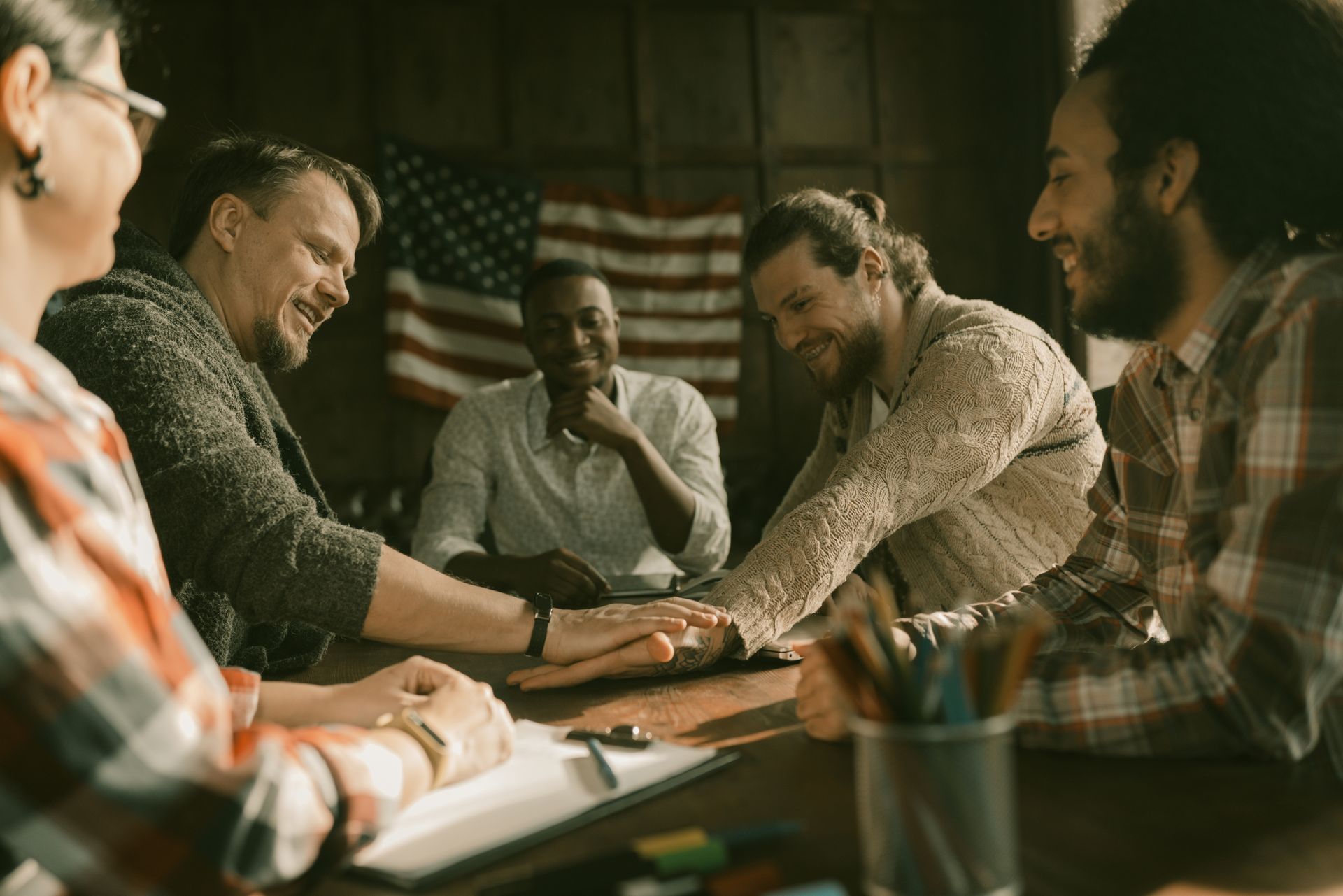 A team of veteran freelancers working together over a laptop beneath an American flag