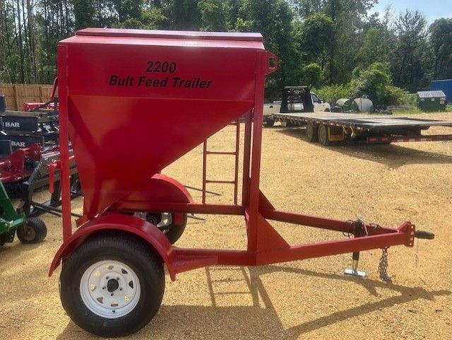 Red bulk feed trailer with white wheels, labeled 