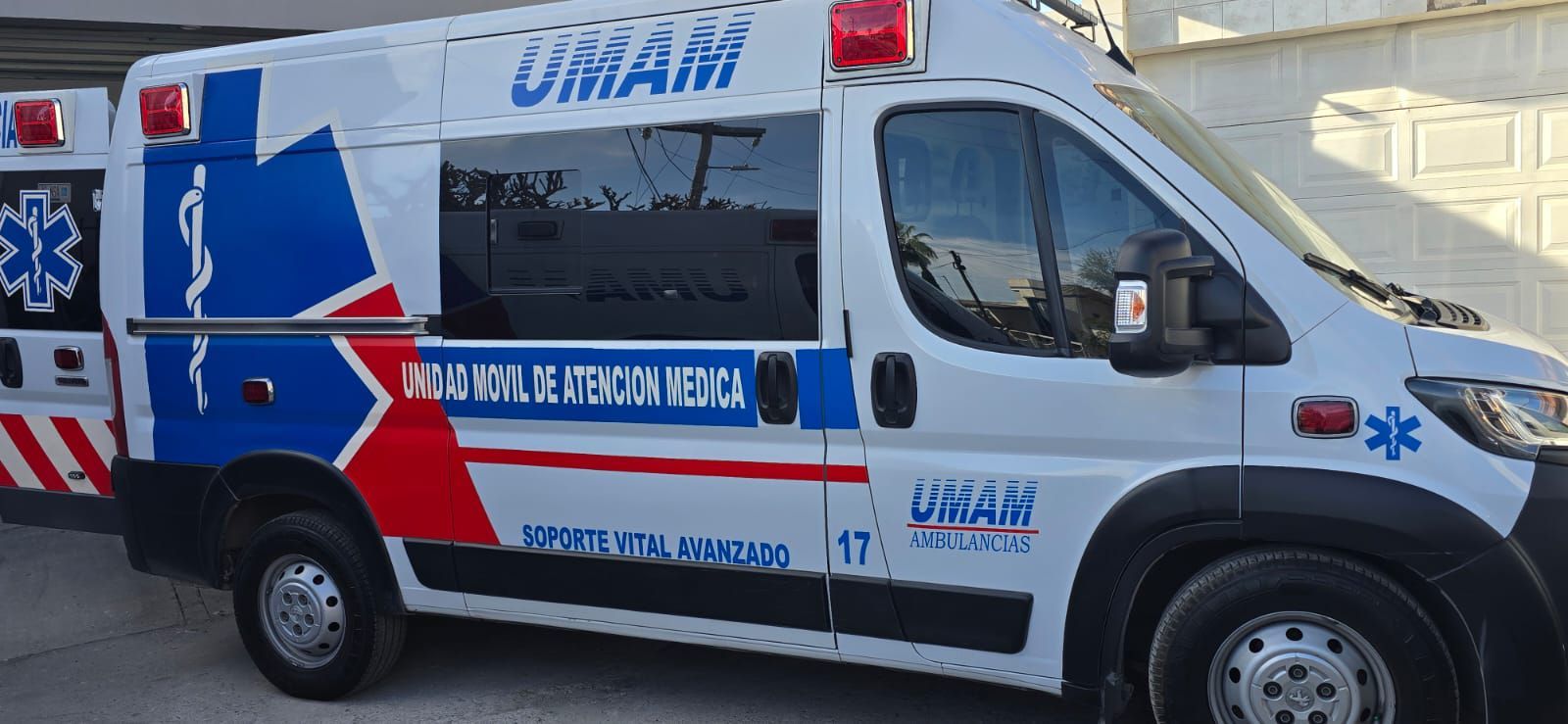 Ambulancia blanca con detalles azules y rojos,