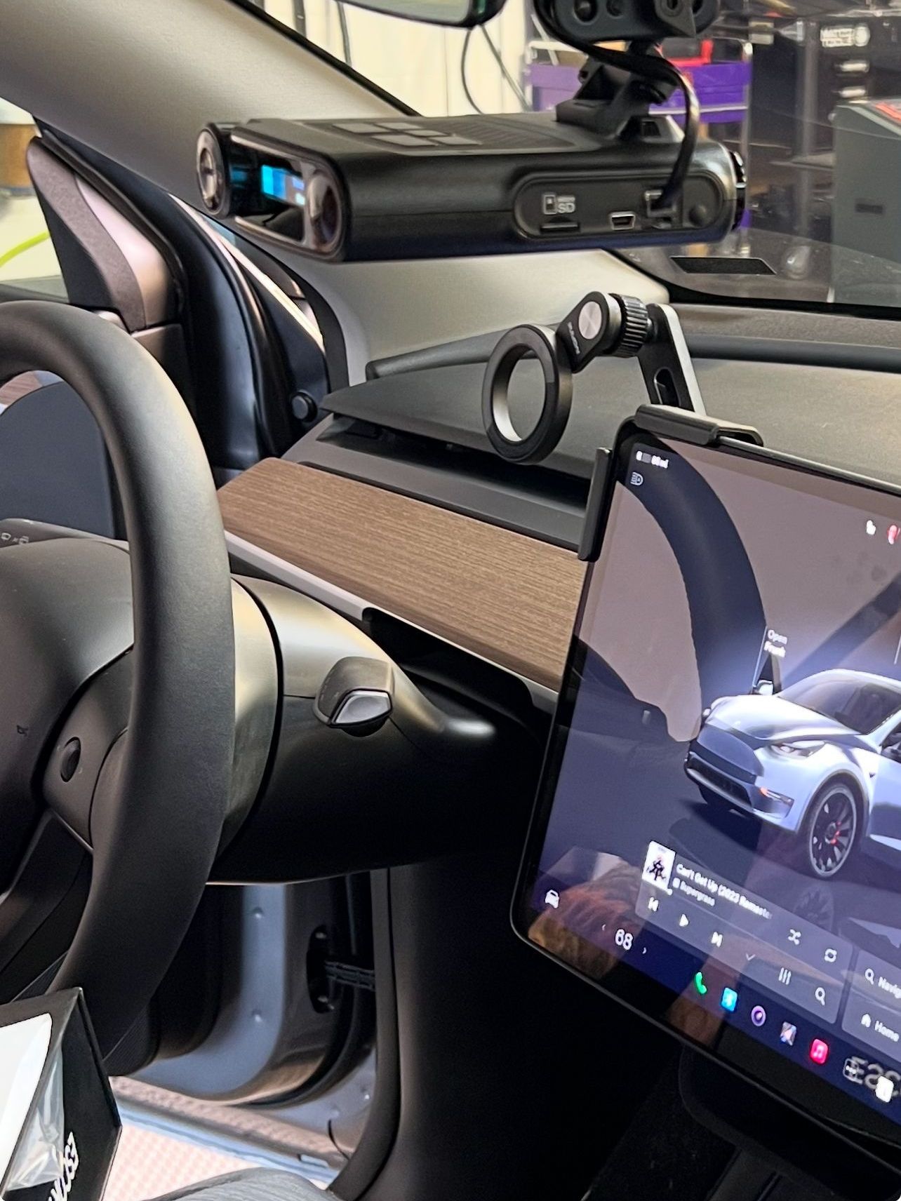 The inside of a tesla model 3 with a tablet on the dashboard