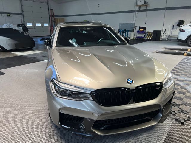 Silver BMW sedan in a garage, viewed from the front.