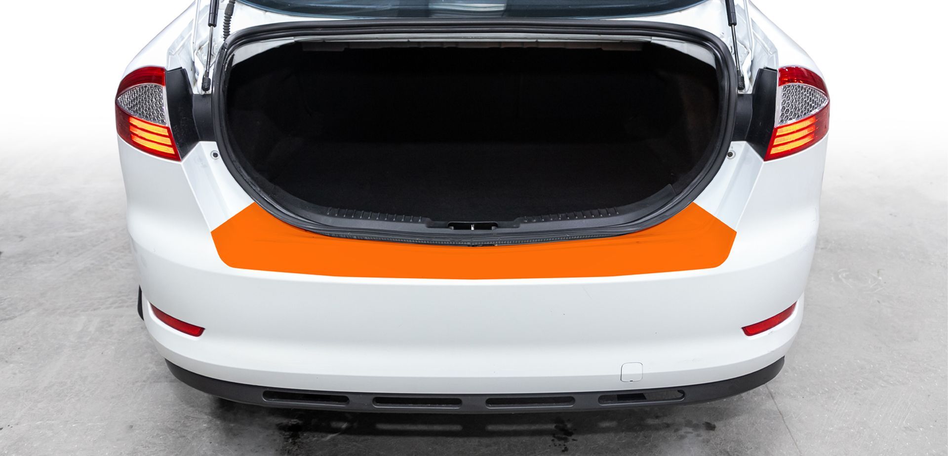 Rear view of a white hatchback with its trunk open, showing orange accent trim and taillights