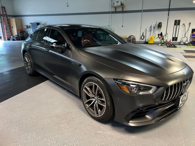 A black mercedes benz is parked in a garage.
