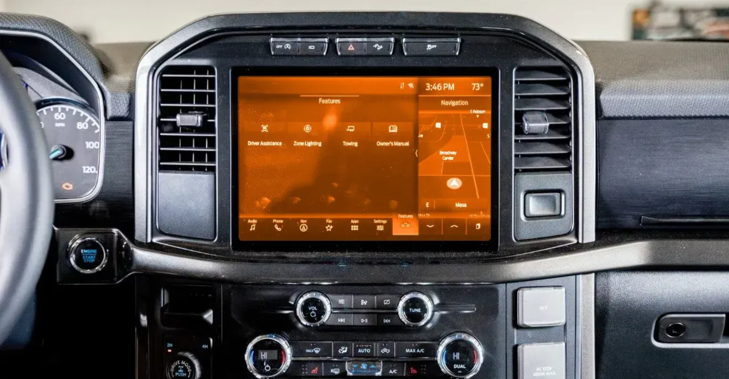 A close up of a car dashboard with a large screen