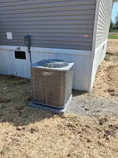 Outdoor air conditioner unit beside a house with beige siding and white skirting