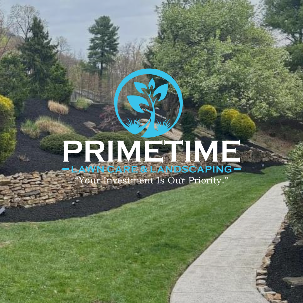 Landscaped backyard with stone wall, green lawn, curved walkway, and Primetime Landscaping logo