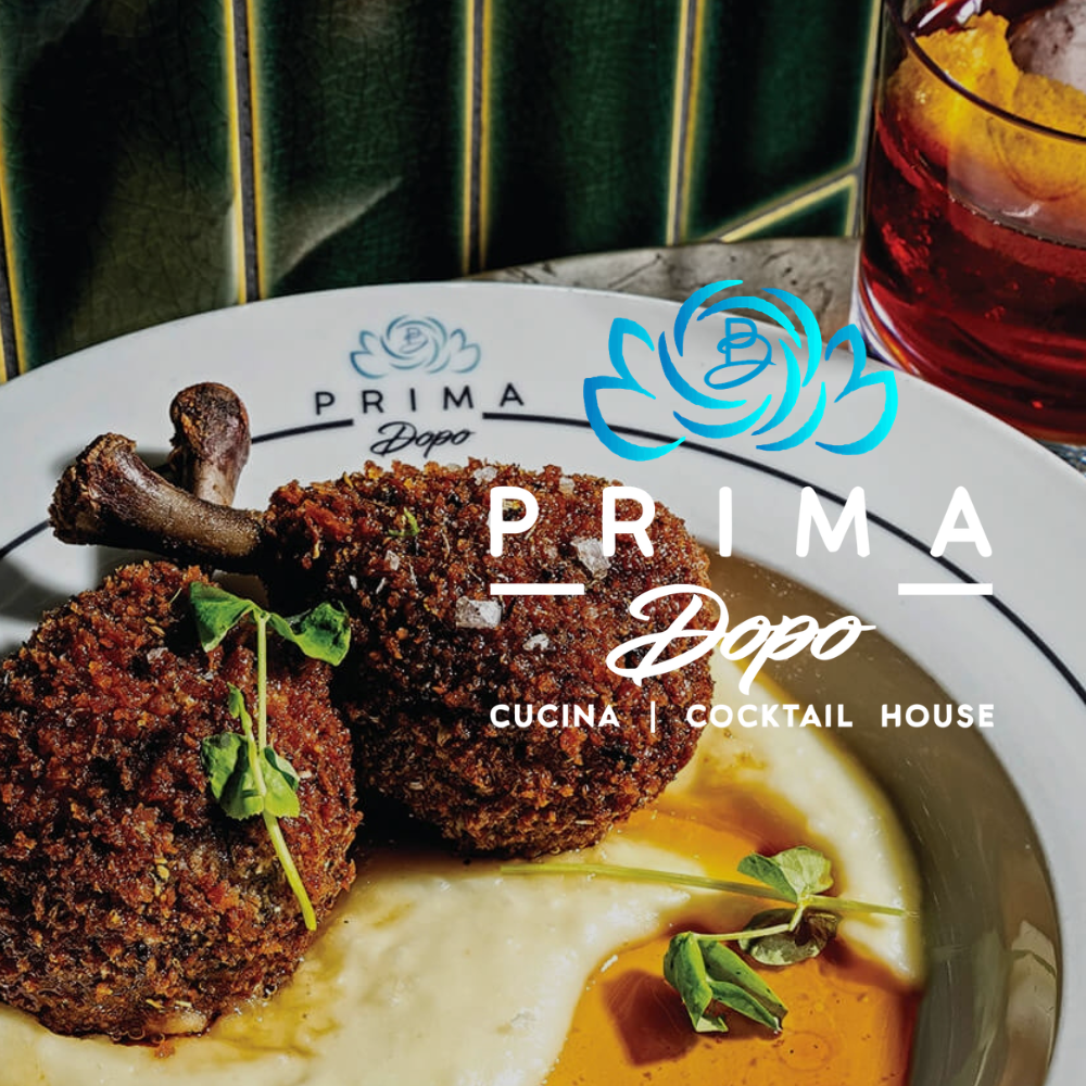Plated steak with sauce and lemon at Prima Dapo Cucina Cocktail House, with a drink in the background