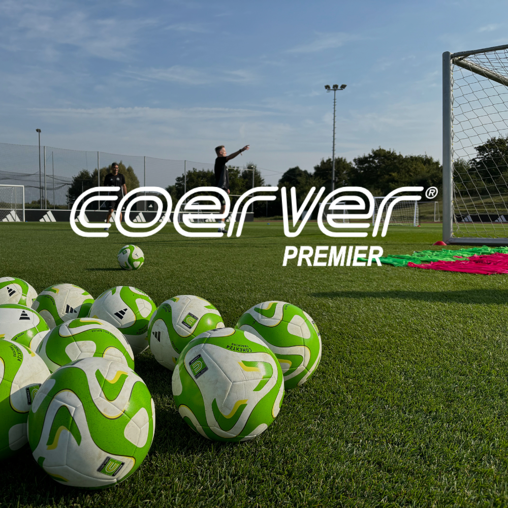 Coerver Premier logo over an image of soccer balls on a soccer field with a coach in the distance