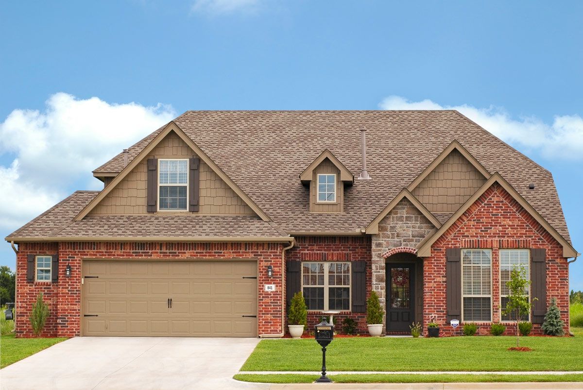 A large brick house with a tan garage door
