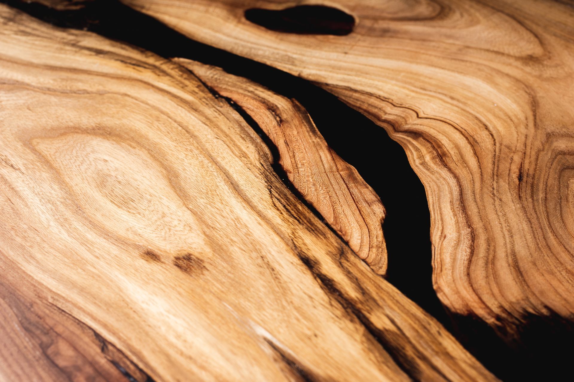 Close-up of a wooden surface with a dark, river-like epoxy inlay.