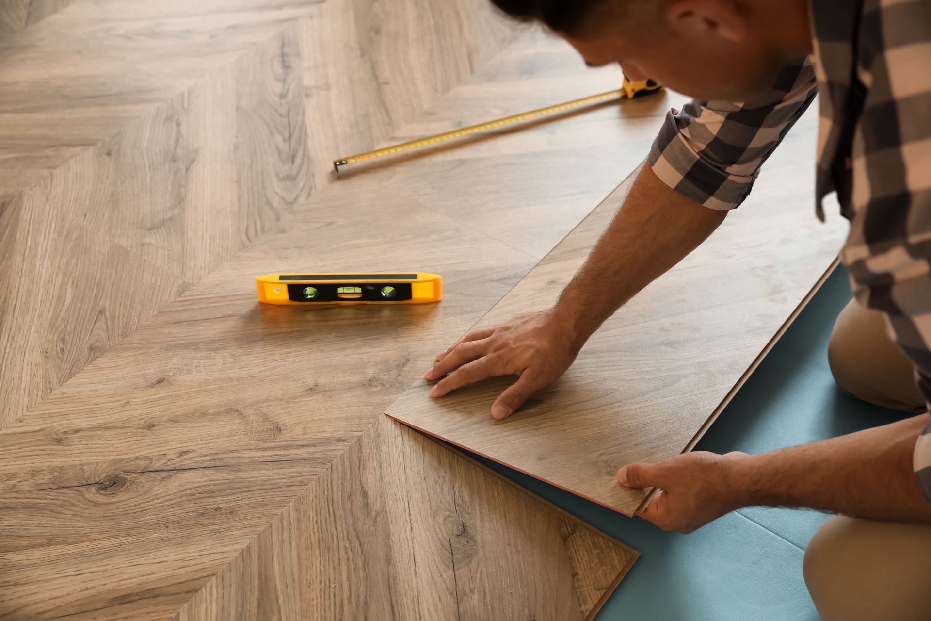 Man installing a wood geometric plank floor.