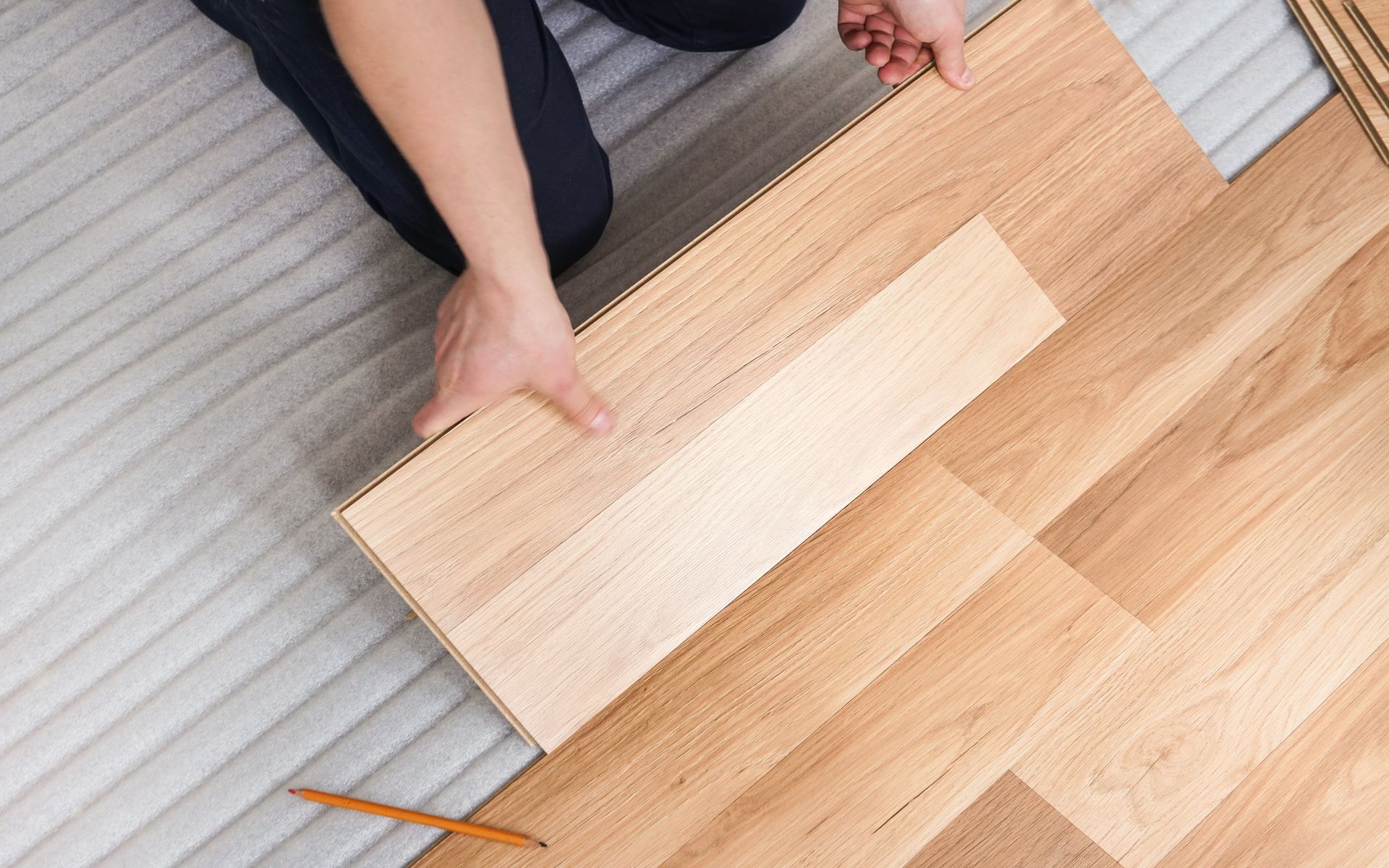Person installing wood flooring.
