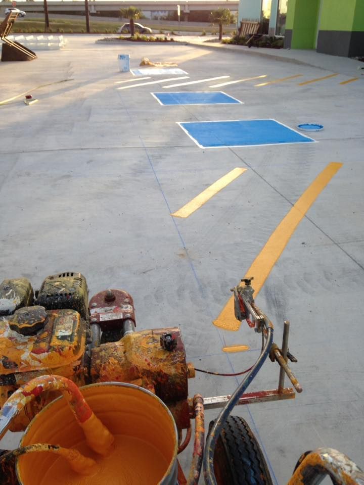 A machine is being used to paint a parking lot